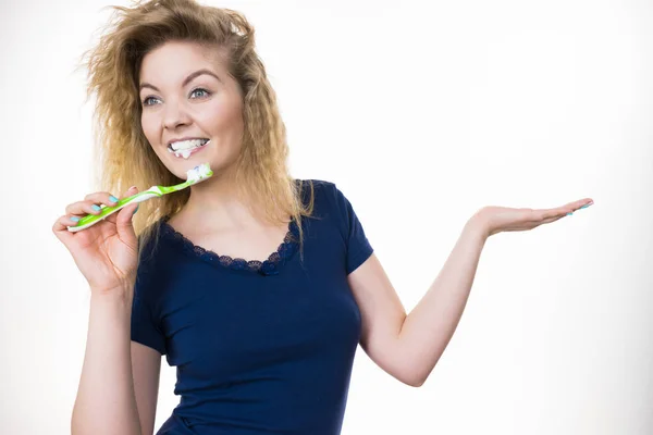 Woman brushing teeth holds open hand — Stock Photo, Image