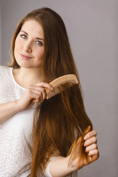 Mulher feliz escovando seu cabelo — Fotografia de Stock