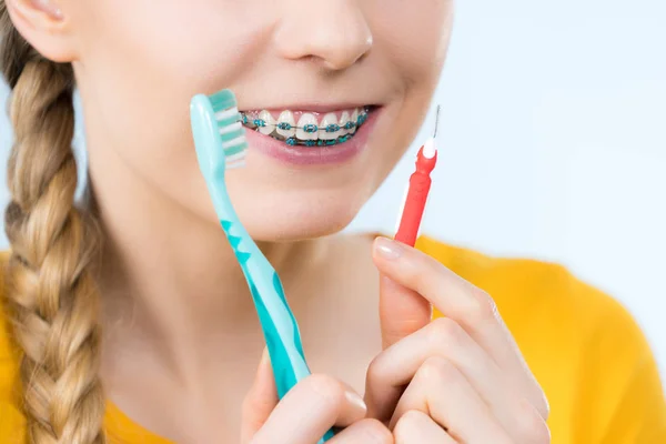 Mulher sorrindo dentes de limpeza com aparelho — Fotografia de Stock