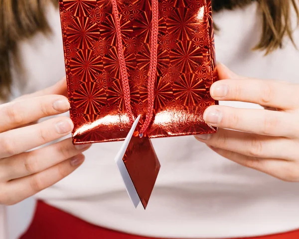 Woman holds red gift bag in hands — Stock Photo, Image