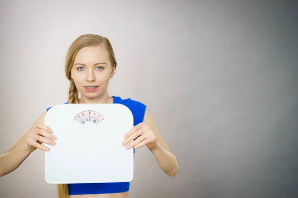 Teenage woman holding bathroom scale machine — Stock Photo, Image