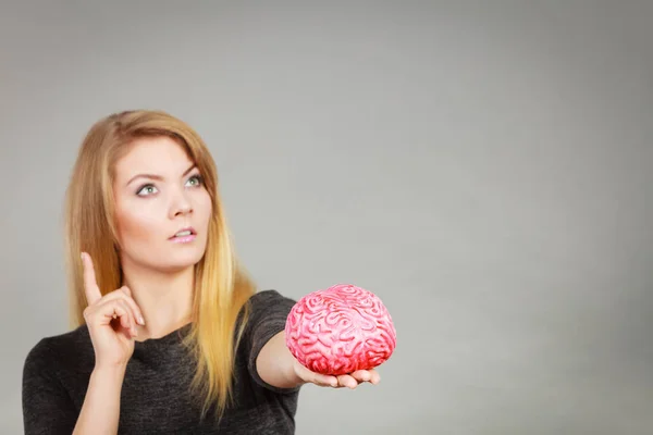 Γυναίκα σκέφτεται και κρατώντας ψεύτικες εγκεφάλου — Φωτογραφία Αρχείου