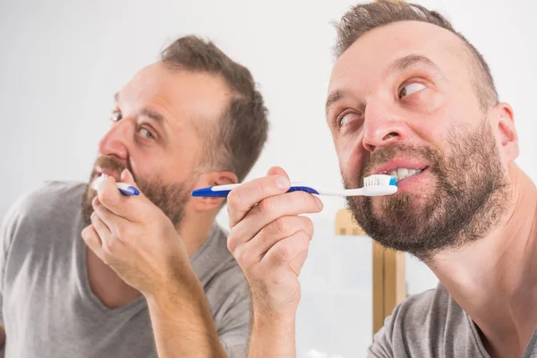 Mann putzt sich im Badezimmer die Zähne — Stockfoto