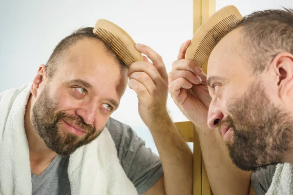 Hombre usando peine en el baño — Foto de Stock