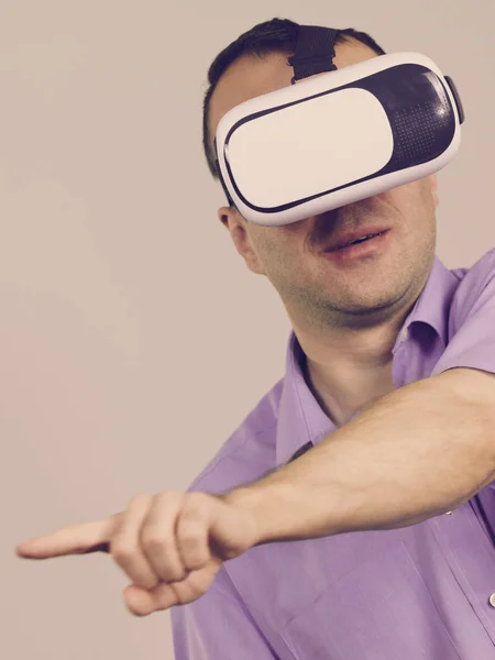 Hombre con gafas de realidad virtual en gris —  Fotos de Stock