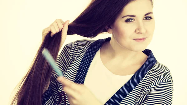 Mulher escovando seu cabelo longo usando pente — Fotografia de Stock