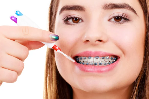 Mujer cepillándose los dientes con aparatos ortopédicos usando cepillo — Foto de Stock