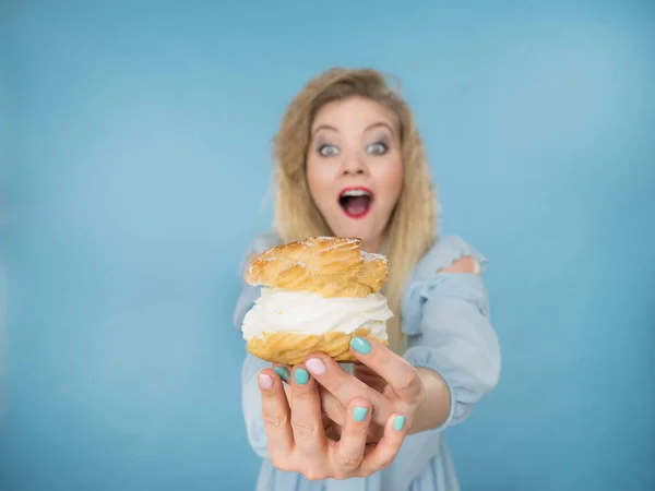 Funny woman holds cream puff cake — Stock Photo, Image