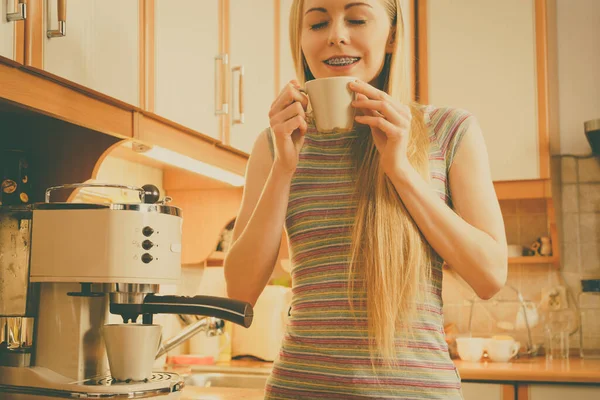 Woman in kitchen making coffee from machine — Stock Photo, Image