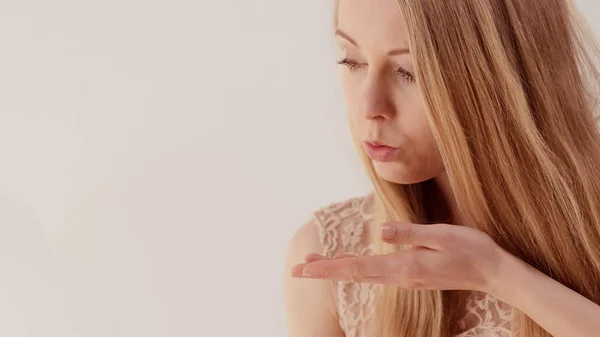 Vrouw blazen kussen op kopieerruimte — Stockfoto