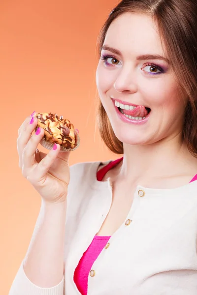 Жінка тримає торт в руці облизуючи губи — стокове фото