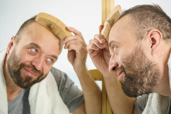 Hombre usando peine en el baño —  Fotos de Stock