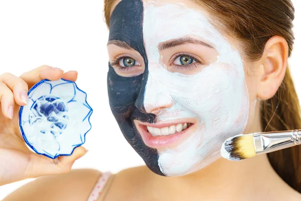 Menina máscara preta na metade do rosto aplicar lama branca — Fotografia de Stock