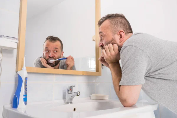 バスルームで彼の歯を磨く退屈な男 — ストック写真