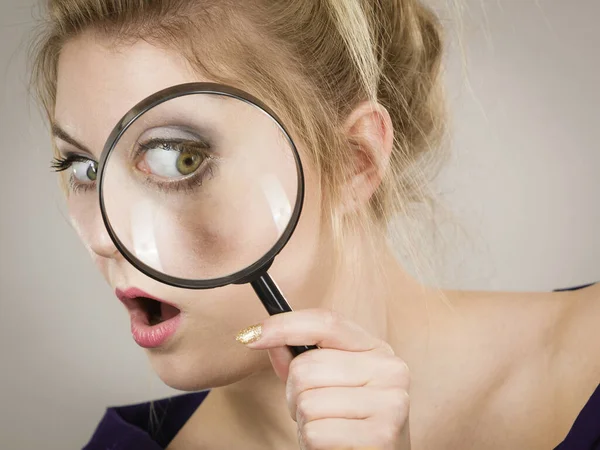 Woman holding magnifying glass investigating — Stock Photo, Image