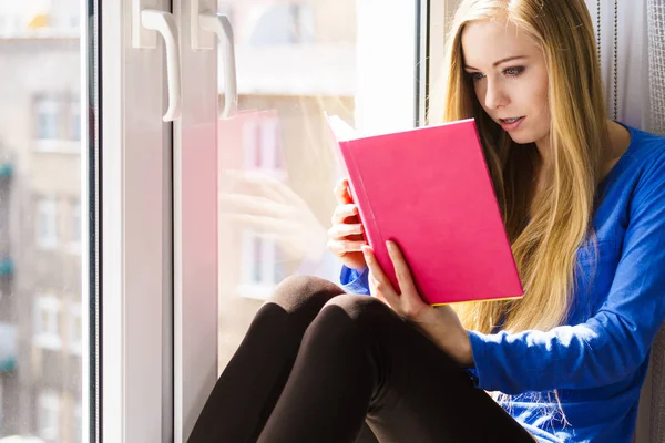 Vrouw zitten op de vensterbank lezen boek thuis — Stockfoto