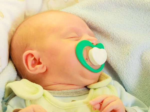 Nahaufnahme eines kleinen Neugeborenen, das mit Zitze im Mund schläft — Stockfoto