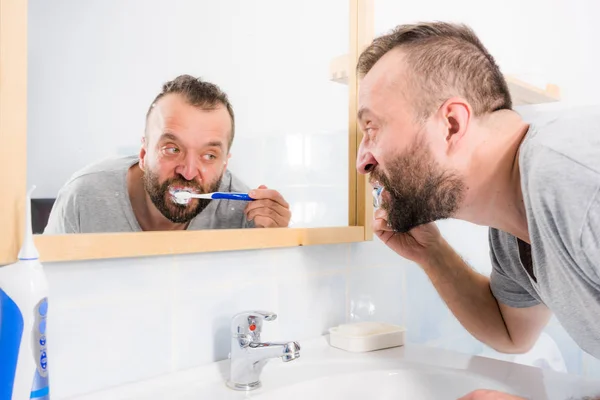 Homme brossant ses dents dans la salle de bain — Photo