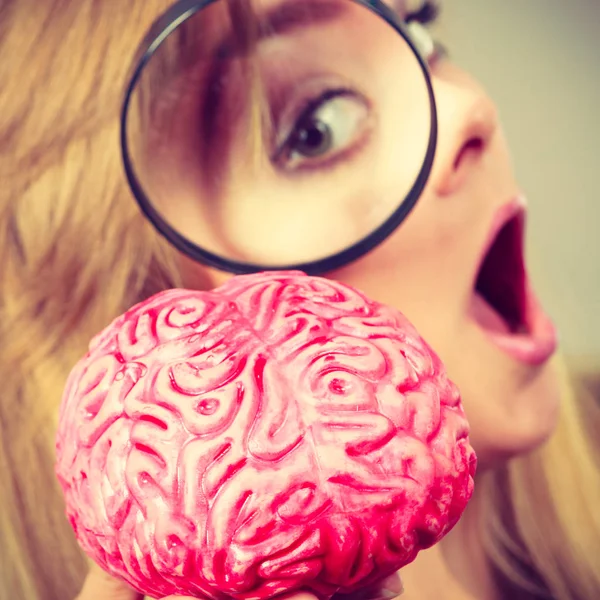 Жінка тримає збільшувальне скло, досліджуючи мозок — стокове фото