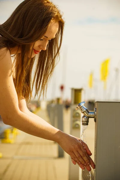 Mujer bebiendo agua del grifo en marina . —  Fotos de Stock