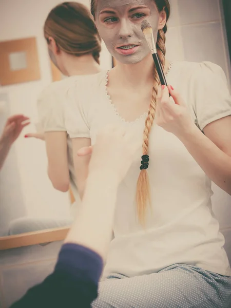 Woman applying with brush clay mud mask to her face — Stock Photo, Image