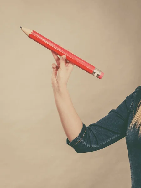 La mano femenina sostiene un lápiz rojo grande — Foto de Stock