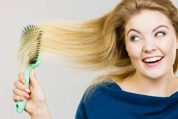 Femme brossant ses cheveux longs avec une brosse — Photo