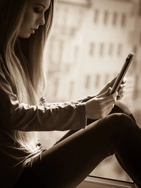 Student meisje met tablet zittend op de vensterbank — Stockfoto