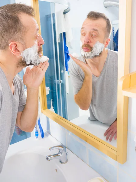 Hombre Aplicando Crema Espuma Afeitar Cara Pie Baño Mirando Espejo — Foto de Stock