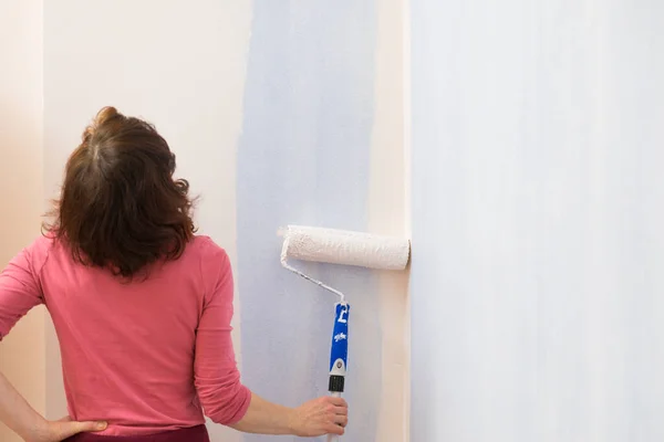 妇女用滚筒刷在墙上喷漆 家庭翻新概念 — 图库照片