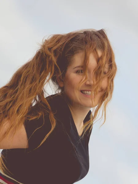 幸せな十代の女性は彼女の余暇時間を楽しんでいる 長い茶色の髪を持っている女性は空を背にポーズ — ストック写真