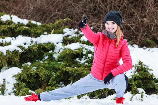 户外运动 运动服创意 冬季穿着保暖运动服的妇女在室外锻炼伸展腿 — 图库照片