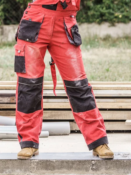 建筑工地上不认识的人穿着保护工人的红裤 — 图库照片