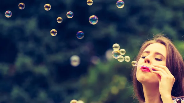 幸福和无忧无虑的概念 开心的年轻女子在公园里吹肥皂泡泡室外 — 图库照片