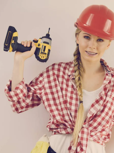 戴头盔的女人用钻头在公寓改造中工作的女孩建筑 维修和翻新 — 图库照片