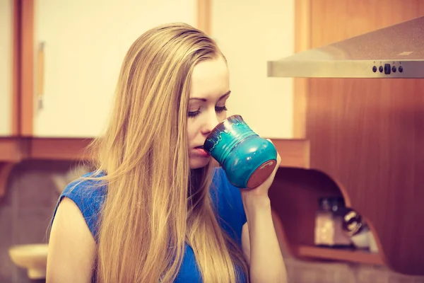 コーヒーのティーカップを持ってキッチンに立つ女性彼女のリラックスした自由な時間を楽しむ — ストック写真