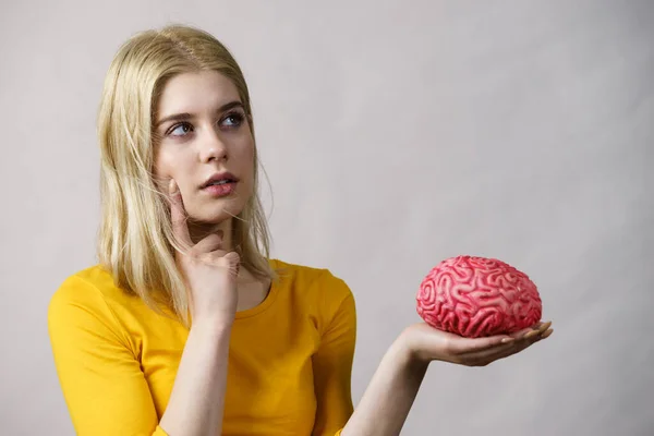 Молодая Женщина Студентка Думает Решении Проблемы Держа Руках Фальшивый Мозг — стоковое фото