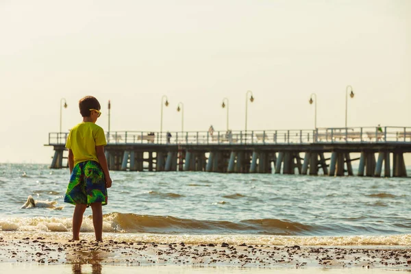 水の楽しさと喜びの外 海海を歩く少年 夏服で野外で遊ぶ孤独な子供 — ストック写真