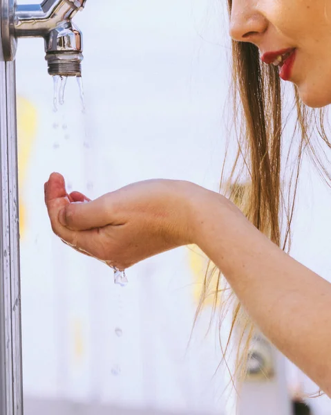 ストリートタップからきれいな水を飲む女性 — ストック写真