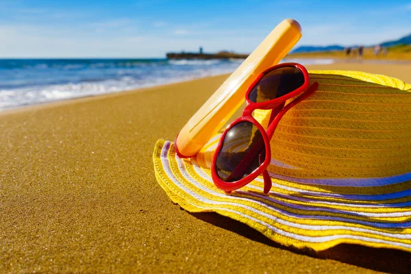 海滨防晒配件 沙滩上的红色太阳镜 黄色草帽和防晒霜瓶 夏季和假日 — 图库照片
