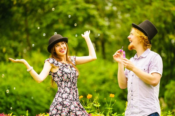 Feliz Divertido Hipster Pareja Jugando Juntos Soplando Jabón Burbujas Aire — Foto de Stock