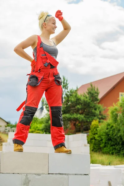 建筑工地上穿着工作服的妇女 女人们休息一下 靠着蓝天站在墙上 部分建造了新房子的早期阶段 — 图库照片