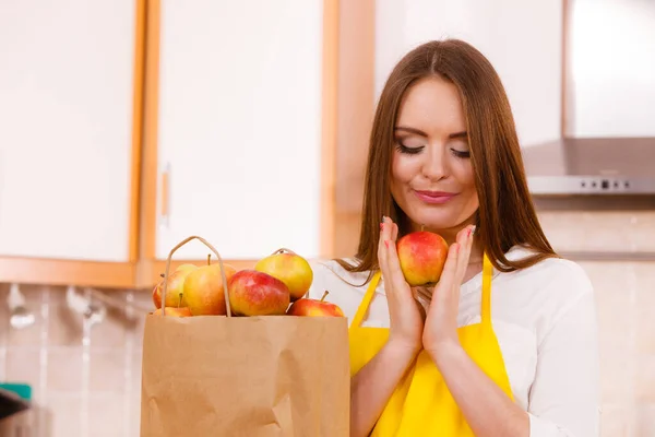 食料品店の買い物袋とキッチンで女性の魅力的な主婦 多くのリンゴの果物 健康的な食事 ベジタリアン料理 人々の概念 — ストック写真