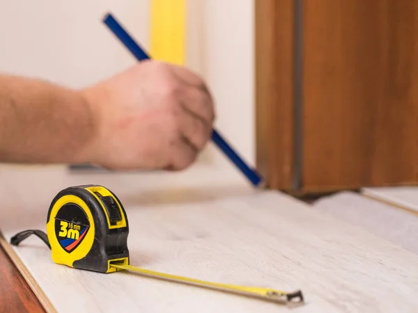 Construcion Worker Measuring Floor Panels Using Ruler Pencil Home Renovation — Stock Photo, Image