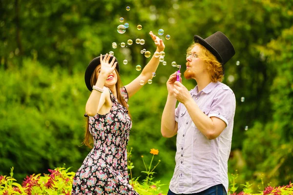 Happy Funny Hipster Couple Playing Together Blowing Soap Bubbles Outdoor — Stock Photo, Image