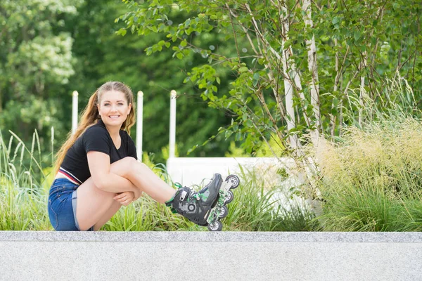 公園で座っているローラー スケートを着ている女性 長い乗車後リラックスした女性 — ストック写真