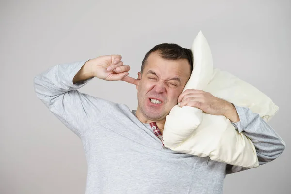 Śpiący Zmęczony Wściekły Facet Trzymający Poduszkę Jednej Zamykający Ucho Drugą — Zdjęcie stockowe