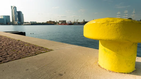 Желтый Металлический Швартовочный Баллард Причале Бетонной Гавани Против Прибрежного Города — стоковое фото