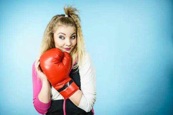 滑稽的金发碧眼的女拳击手 戴着大大的有趣的红色手套 打着拳击工作室的蓝色镜头 — 图库照片