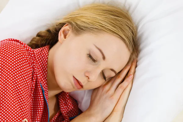 安静時の睡眠位置の概念を緩めなさい 夢の中で溺れている少女 赤い点線のパジャマを着た若い女性がベッドの上に横になって深く夢を見て — ストック写真